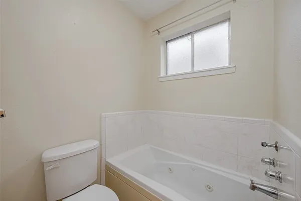 a white bath tub sitting next to a toilet