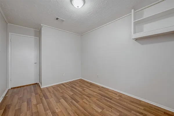 a view of empty room with wooden floor
