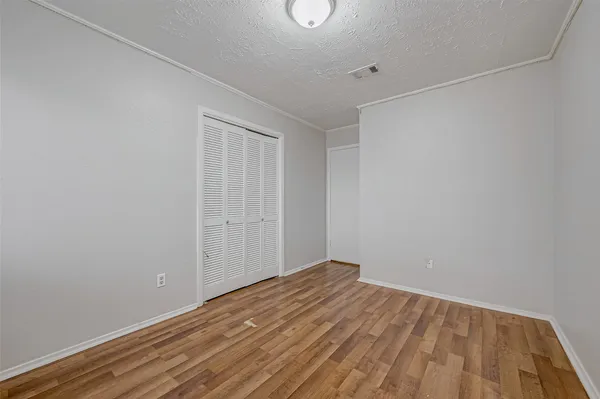 a view of empty room with wooden floor