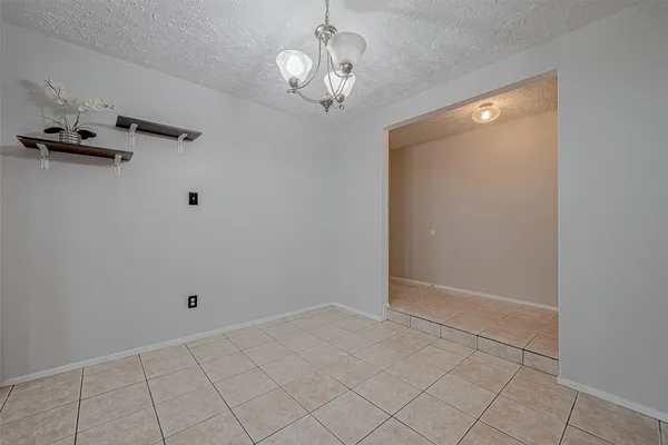 a view of a chandelier fan and hardwood floor