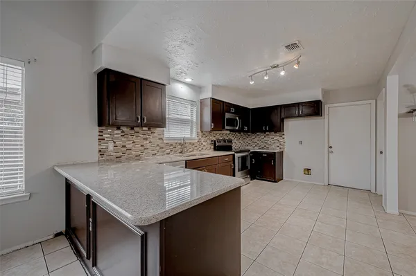 a kitchen with a stove a refrigerator and a sink