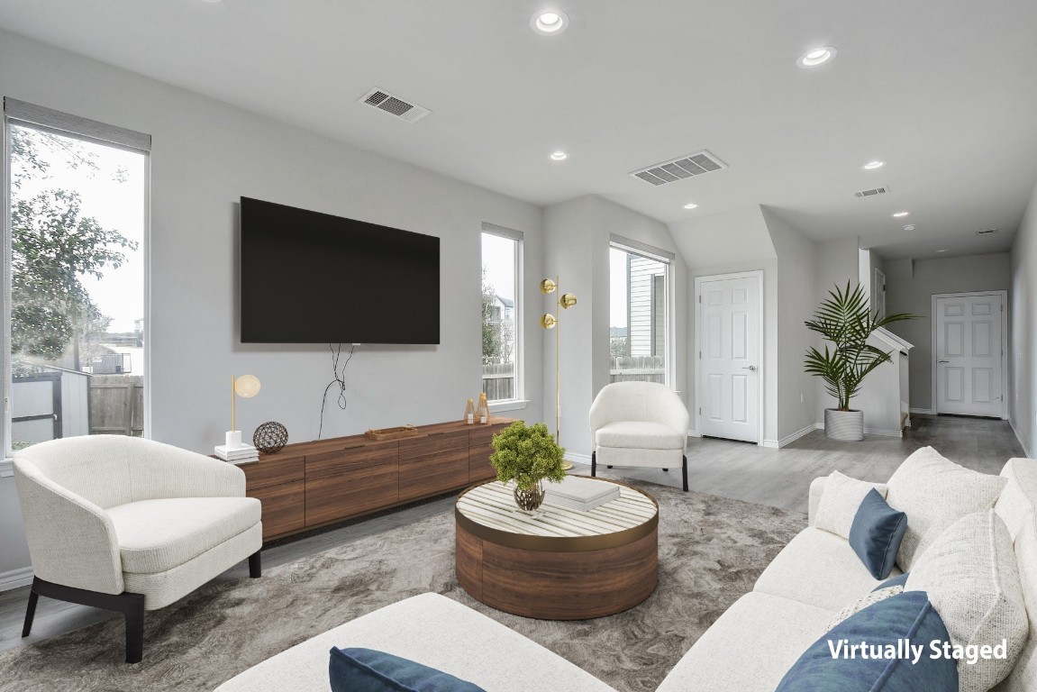 a living room with furniture a flat screen tv and a large window