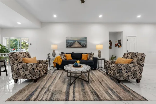 a living room with furniture and a ceiling fan