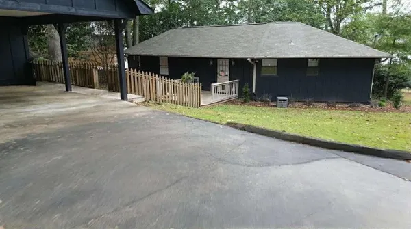 a front view of house with yard and trees in the background