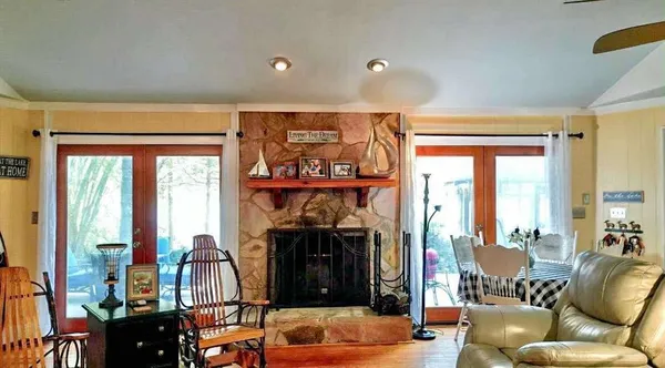 a living room with furniture a fireplace and a floor to ceiling window