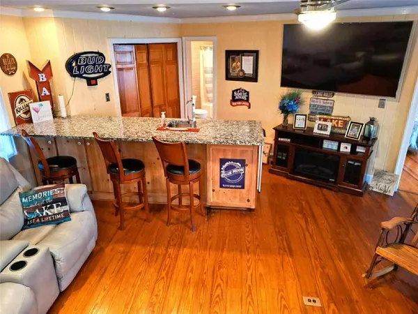 a living room with stainless steel appliances furniture and a flat screen tv