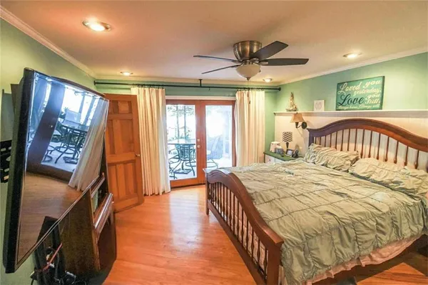 a bedroom with a bed next to a window with a flat screen tv