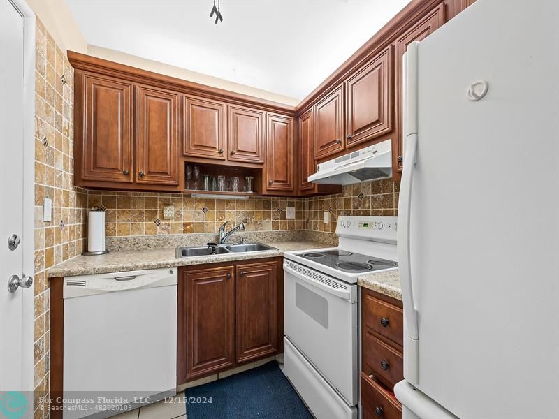 2990 Northeast 16th Avenue, Unit C306 Oakland Park, FL 33334 - Photo 8 of 11 a kitchen with stainless steel appliances granite countertop a sink and cabinets
