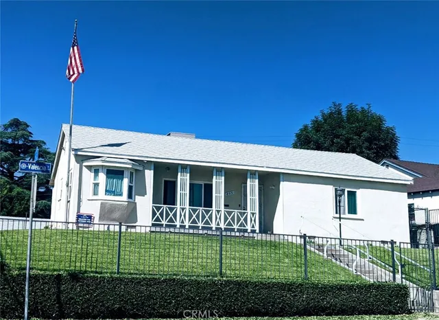 a view of a house with a yard and potted plants