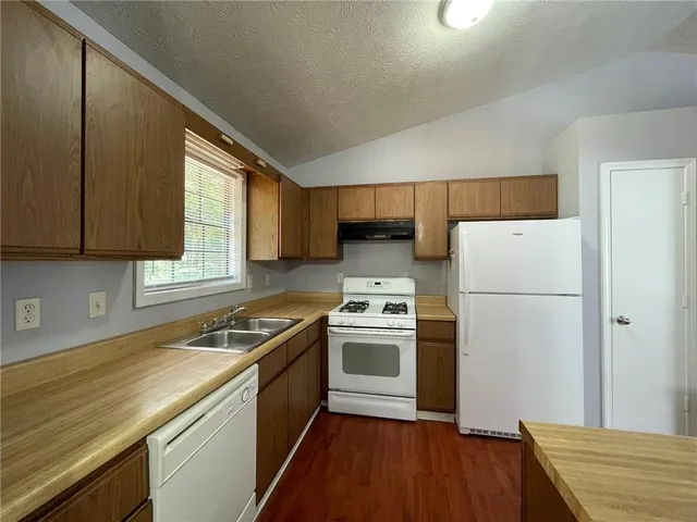 a kitchen with a sink a refrigerator and cabinets