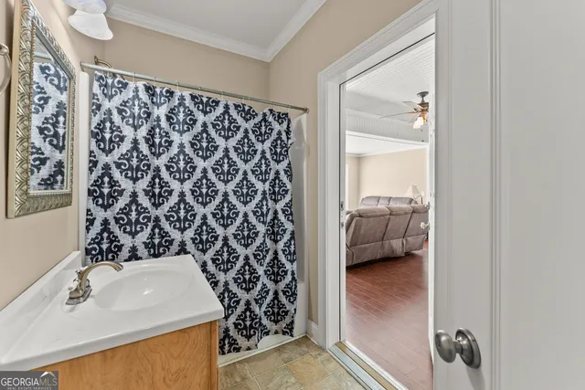 a view of a livingroom with wooden floor and a ceiling fan