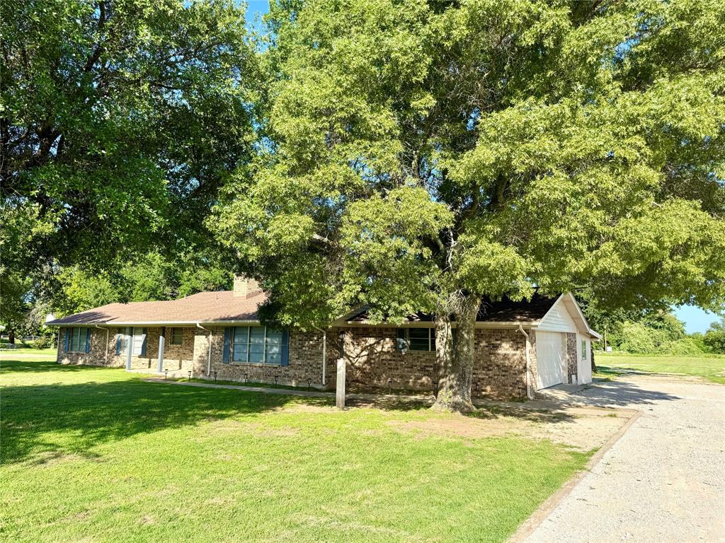 a front view of a house with a yard and trees