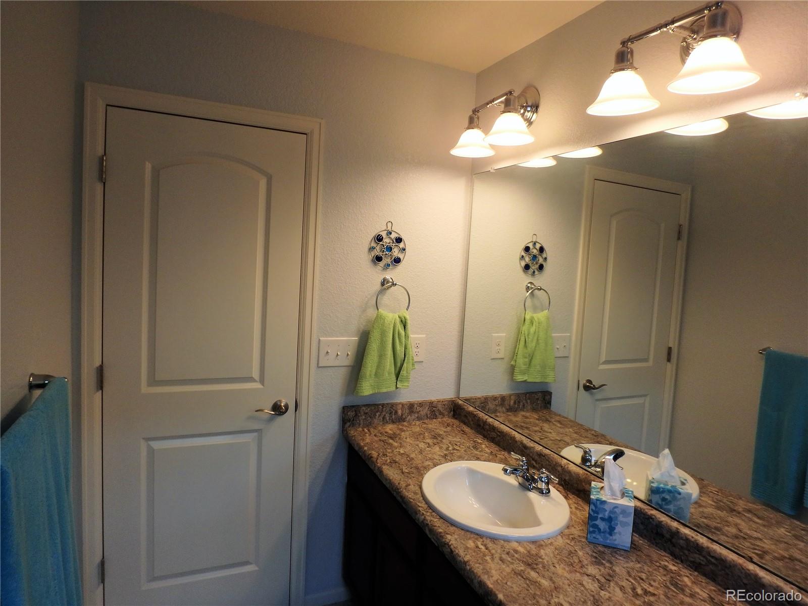 3268 Raintree Lane Dacono, CO 80514 - Photo 17 of 35 a bathroom with a granite countertop sink and a mirror