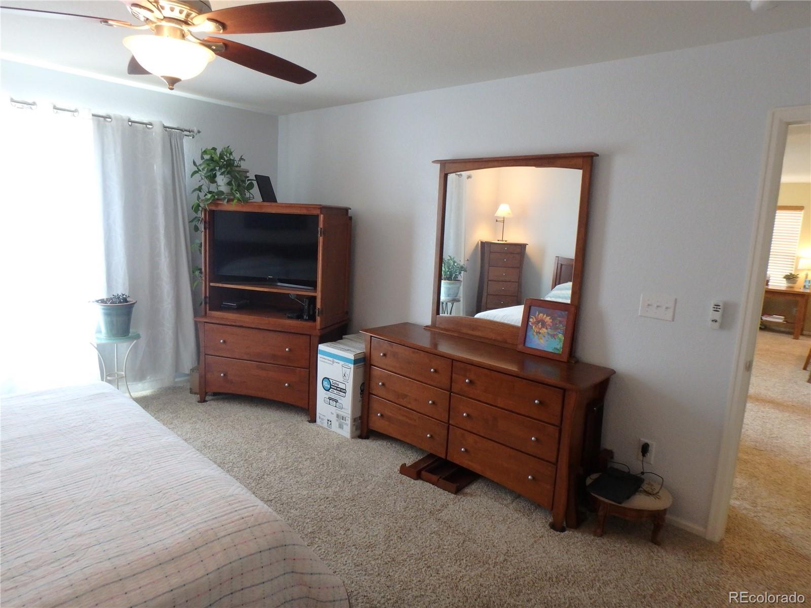 3268 Raintree Lane Dacono, CO 80514 - Photo 20 of 35 a room with furniture and a flat screen tv