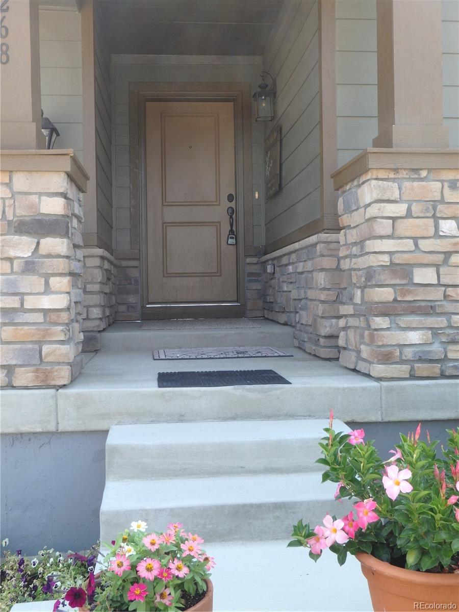 3268 Raintree Lane Dacono, CO 80514 - Photo 3 of 35 a view of path and flowers in front of door