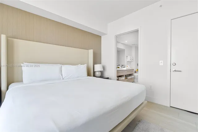 a bedroom with a bed and a large mirror