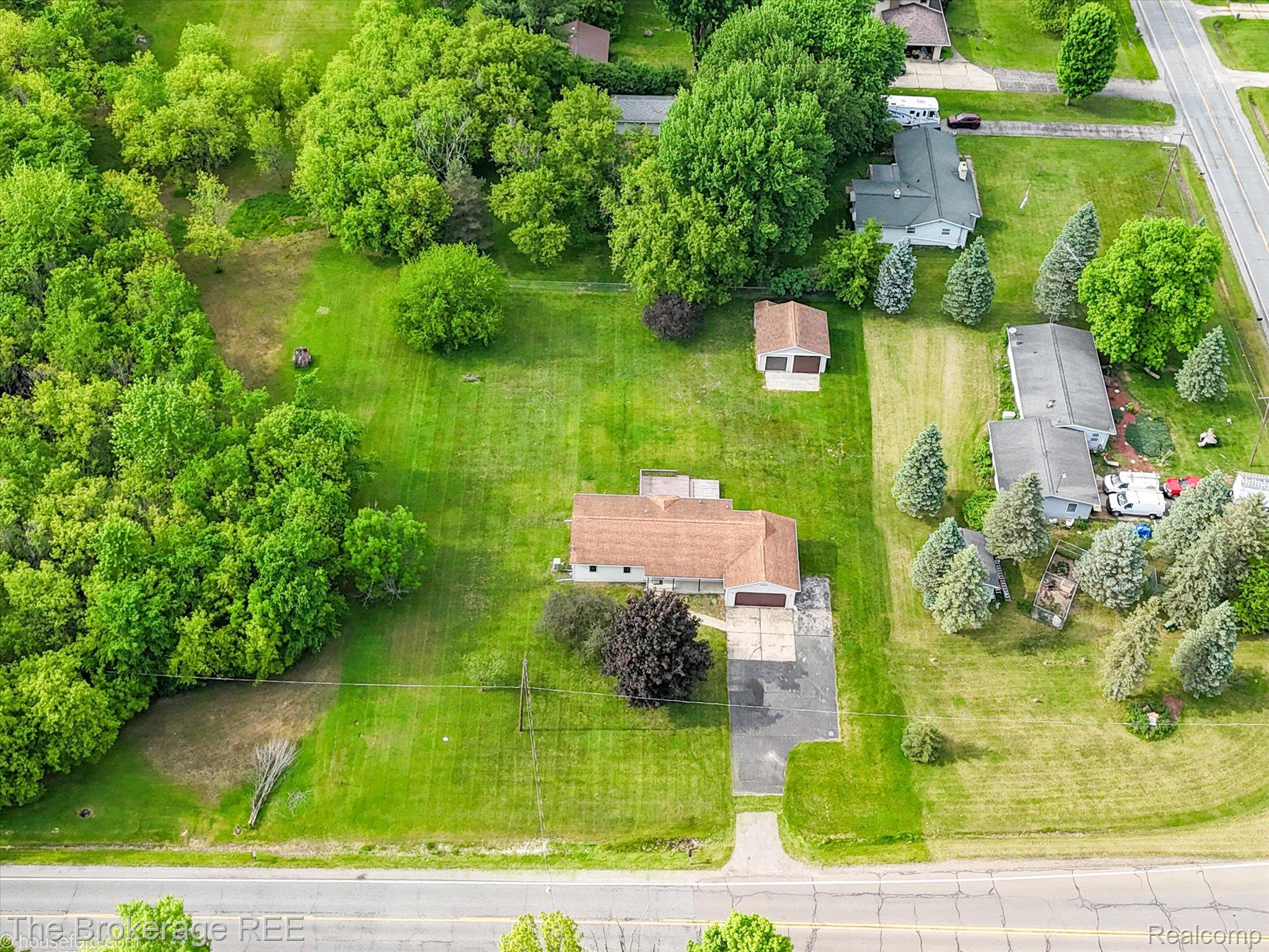 5495 East Coldwater Road Flint, MI 48506 - Photo 5 of 44 Aerial view showcasing a residential property with a central dwelling featuring a light-colored exterior and a brown roof
