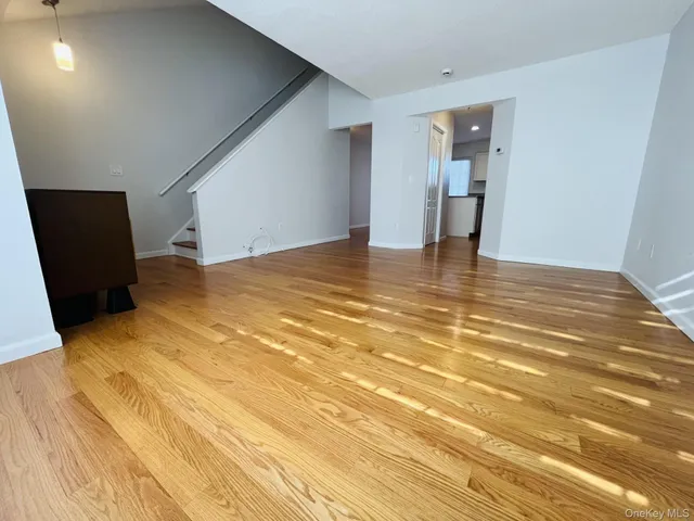 a view of an empty room with closet and wooden floor