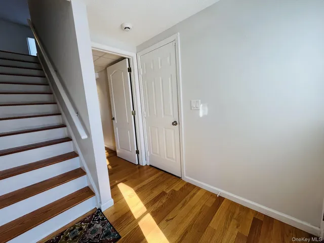 a view of a hallway with wooden floor and staircase