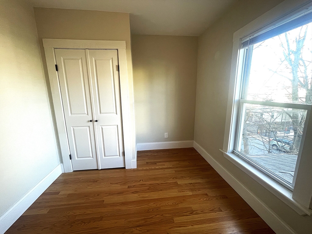 22 Mansfield Street, Unit 2 Boston, MA 02134 - Photo 17 of 18 an empty room with wooden floor and windows