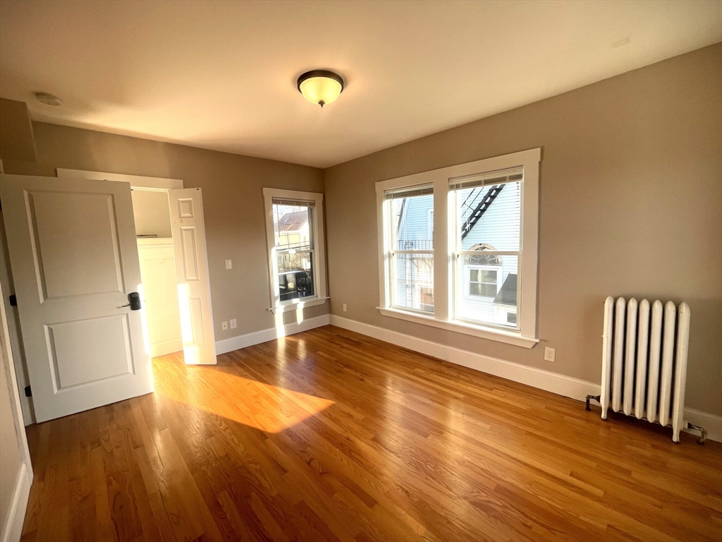 22 Mansfield Street, Unit 2 Boston, MA 02134 - Photo 3 of 18 an empty room with wooden floor and windows