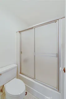 a white toilet sitting next to a shower