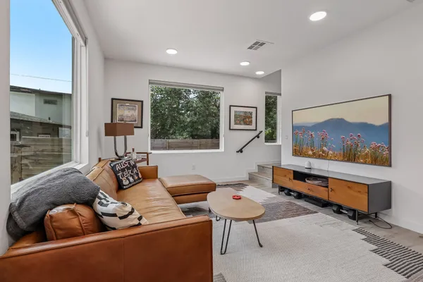 a living room with furniture a flat screen tv and a painting on the wall