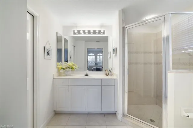 a spacious bathroom with a shower sink and mirror