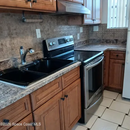 a kitchen with granite countertop a sink stove and cabinets