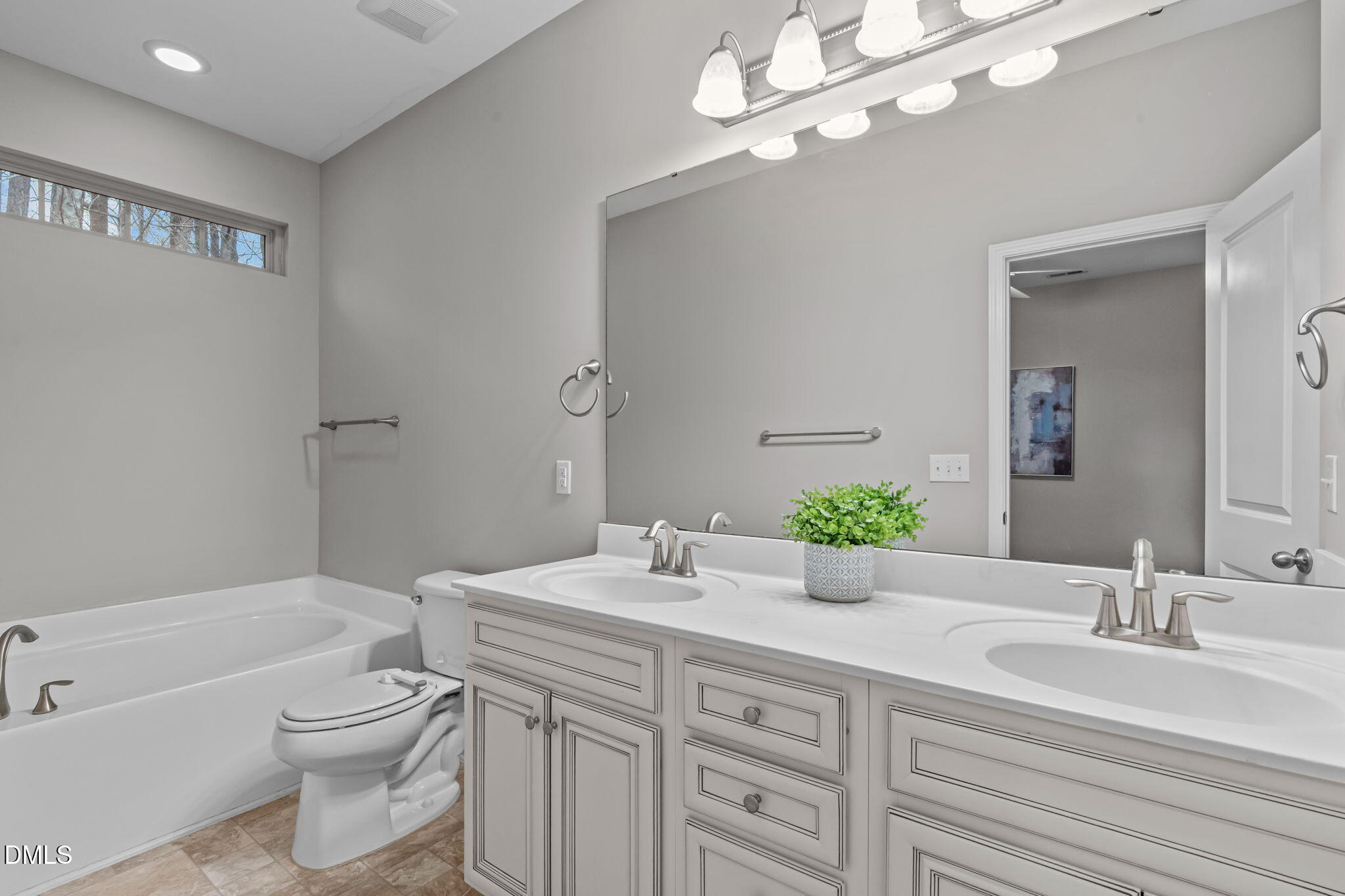 738 Wickham Ridge Road Apex, NC 27539 - Photo 12 of 27 a bathroom with a double vanity sink toilet and shower