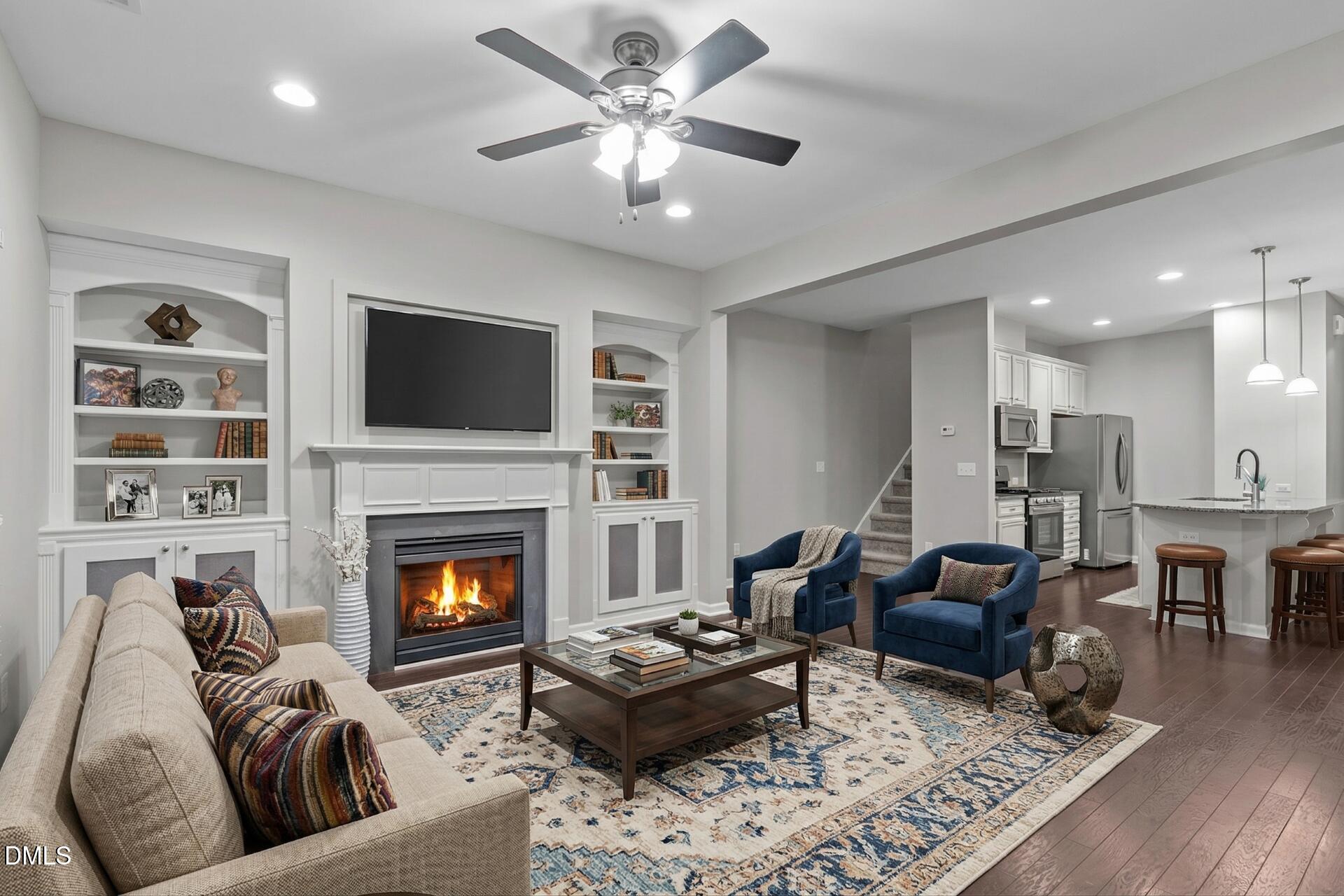 738 Wickham Ridge Road Apex, NC 27539 - Photo 4 of 27 a living room with furniture fireplace and a flat screen tv