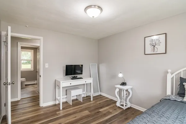 a view of a livingroom with wooden floor and a flat screen tv