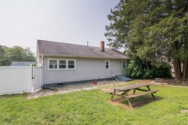 a view of a house with backyard and a tree