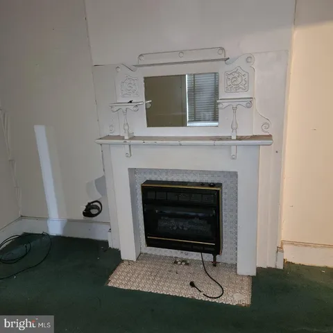 a view of a livingroom with wooden floor and a fireplace