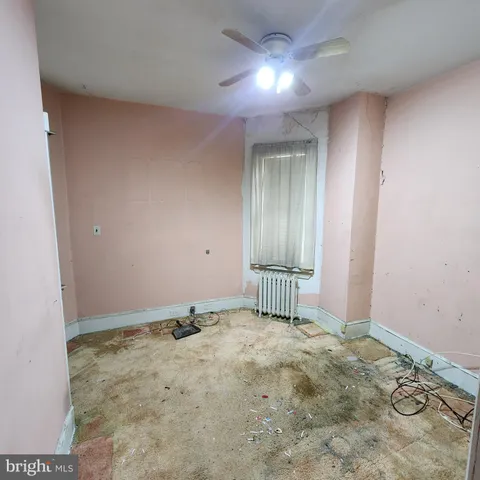 an empty room with a ceiling fan and window