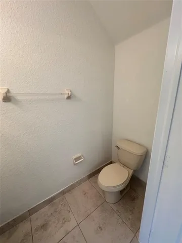 a white toilet sitting next to a white sink and vanity