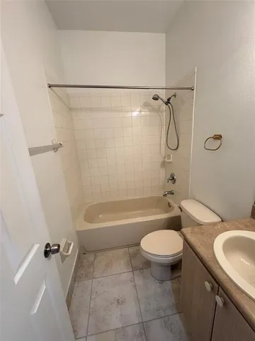 a bathroom with a granite countertop toilet a sink and a bathtub