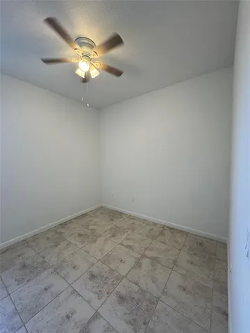 an empty room with a chandelier fan