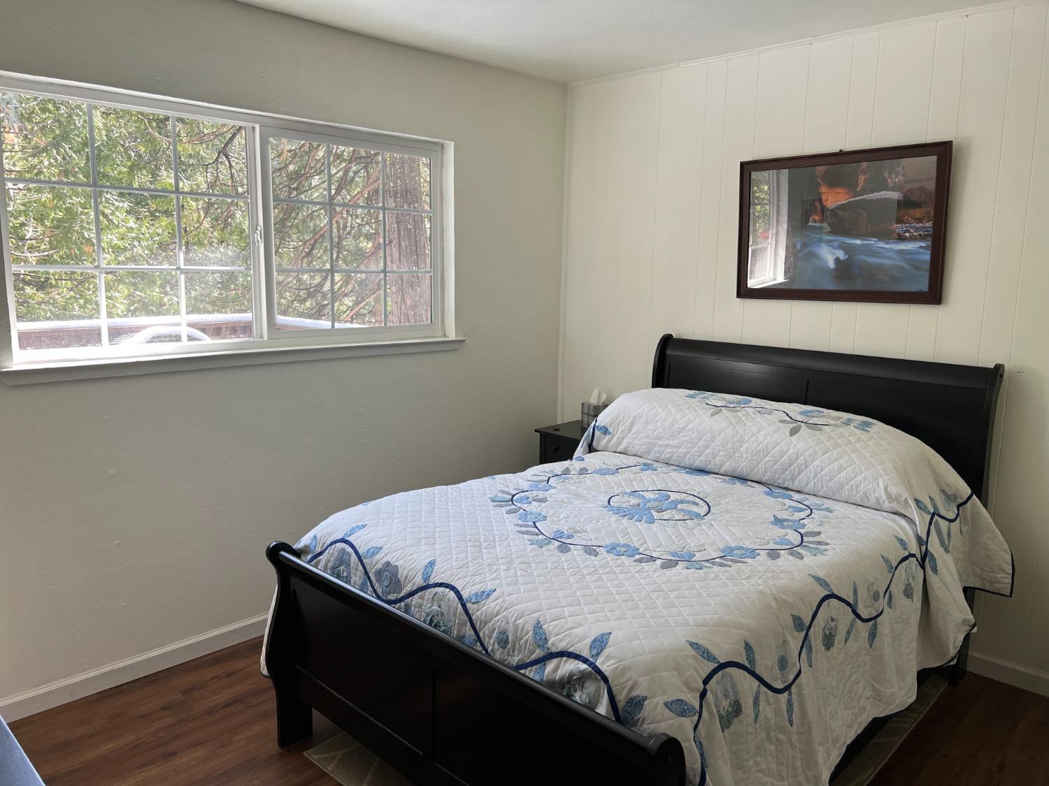 26445 Crystal Road Long Barn, CA 95335 - Photo 5 of 22 a bedroom with a bed and wooden floor