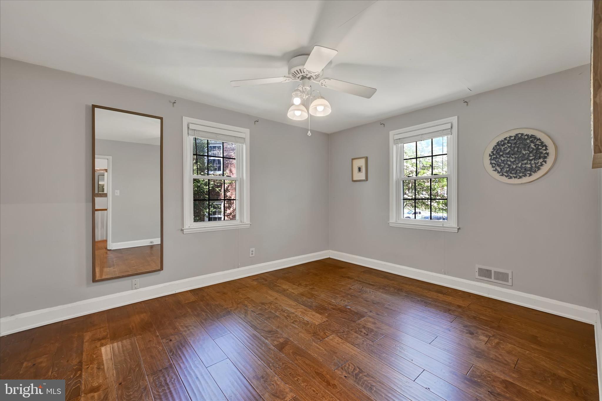 7220 Lanark Road Baltimore, MD 21212 - Photo 15 of 28 an empty room with wooden floor chandelier fan and windows