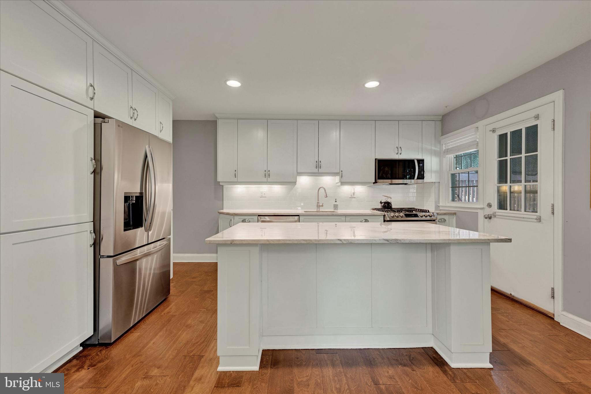 7220 Lanark Road Baltimore, MD 21212 - Photo 8 of 28 a kitchen with kitchen island a sink a stove a refrigerator and white cabinets