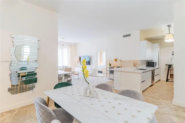 a view of kitchen with kitchen island stainless steel appliances a sink a counter top space and living room view