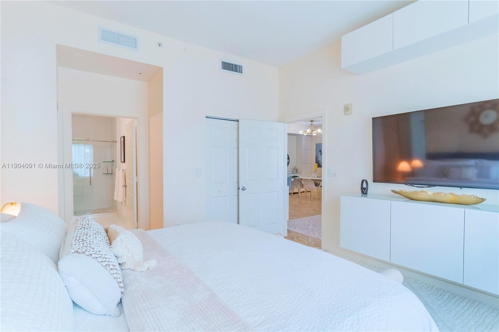 802 West Windward Way, Unit 411 Lantana, FL 33462 - Photo 21 of 42 a bedroom with a bed and a flat screen tv