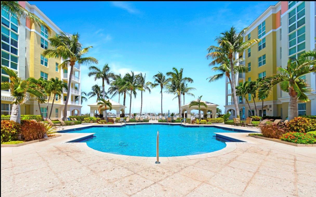 802 West Windward Way, Unit 411 Lantana, FL 33462 - Photo 40 of 42 a view of a swimming pool with a lawn chairs and palm trees