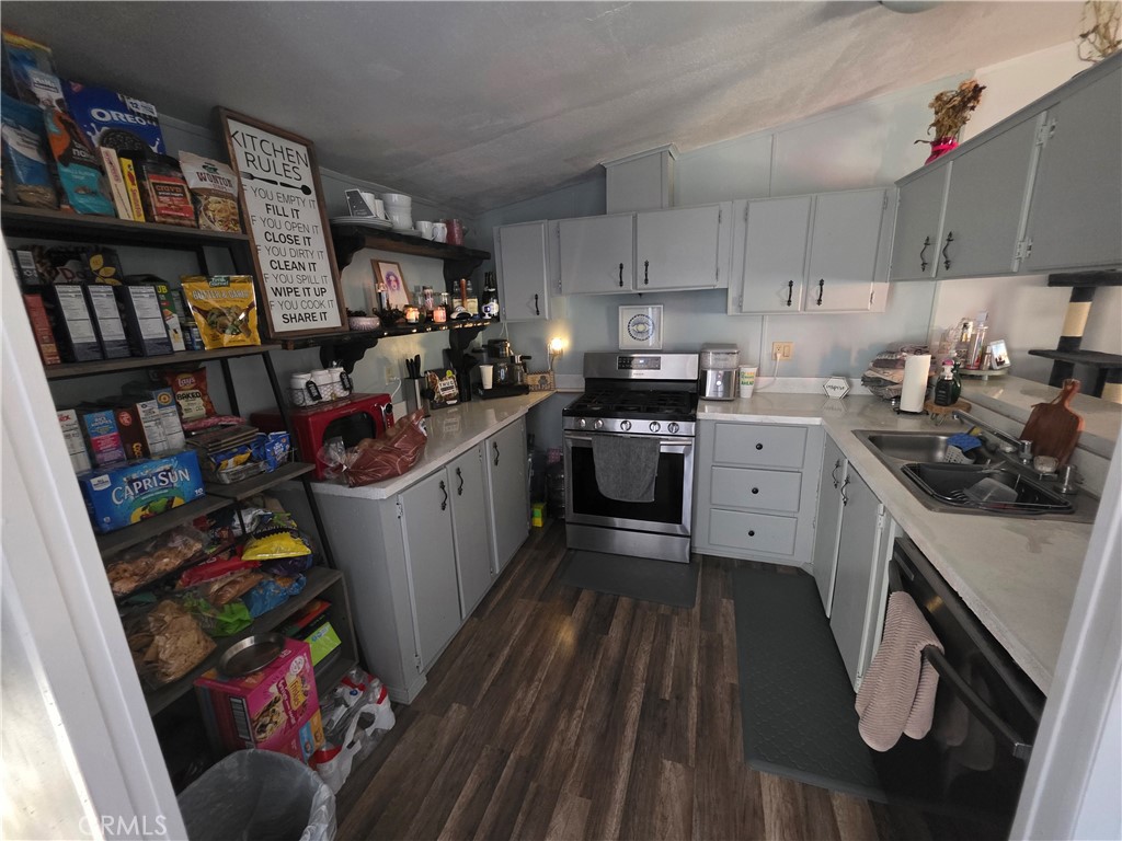 10623 Desert View Road Pinon Hills, CA 92372 - Photo 41 of 76 a kitchen with lots of clutter and cabinets