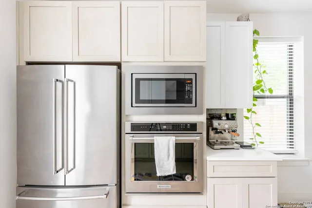 a kitchen with windows and white cabinets