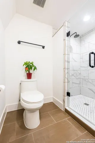 a bathroom with a toilet and a shower