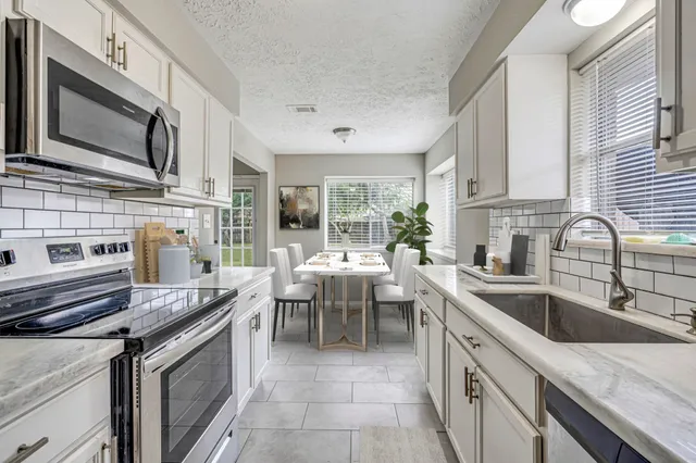 a kitchen that has a sink and a stove top oven