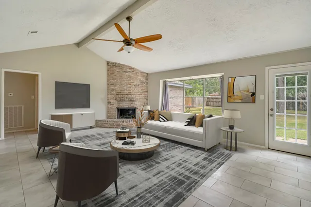 a living room with fireplace furniture and a floor to ceiling window