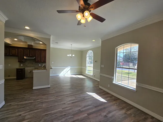 an open kitchen with kitchen island stainless steel appliances furniture and a large window